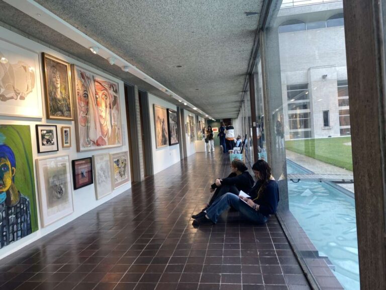 Young people sat down drawing in the corridor of Kettle’s Yard gallery