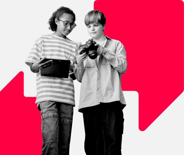 Two young people look are looking at an image on a DSLR camera. One is holding an Ipad