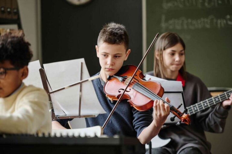 Boy playing a violin reading sheet music