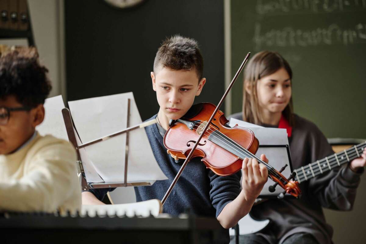 Boy playing a violin reading sheet music